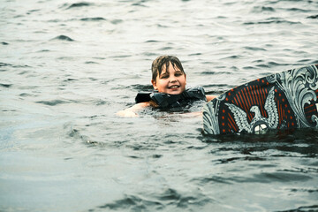 Boy is learning to ride a wakeboard.