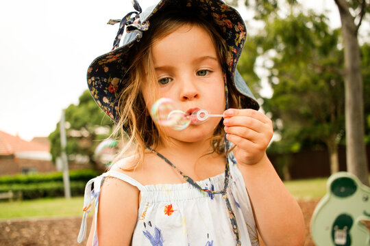 Young girl blowing bubbles in a park