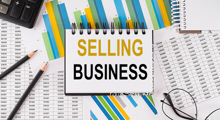 Closeup a notebook with text SELLING BUSINESS , business concept image on chart background