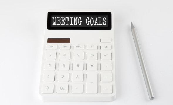 MEETING GOALS business text on calculator with pencil