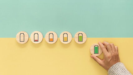 Hand hold wooden cube with symbol full level energy battery green. Concept of work motivation,...