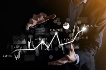 Fototapeta premium Businessman in hand hold banking business finance graph and invest in stock market investment point,economic growth and investor concept.analysis virtual stock market chart,analyze by use technology