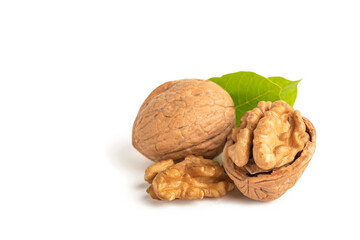 Peeled walnut fruits lie on a white isolated background with green leaves. Walnut in shell. White...