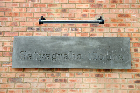 Closeup Shot Of Old Metal Signage With Satyagraha House Text Against Brick Walls