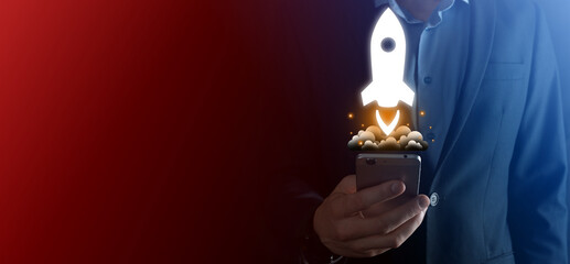 Startup business concept, Businessman holding tablet and icon rocket is launching and soar flying...
