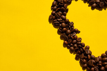 Top view of coffee beans on a yellow background