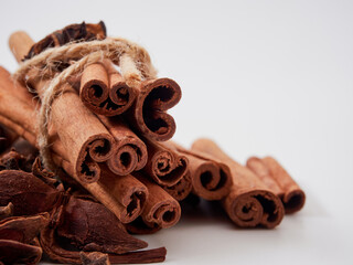 a stick of cinnamon and a star of anise spices are isolated on a white background close-up