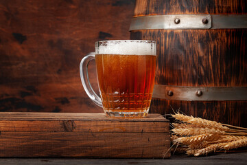 Mug of light lager beer and old wooden barrel