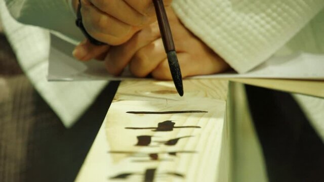 Korean artist write Chinese calligraphy on Korean Hanok wooden beam, close-up