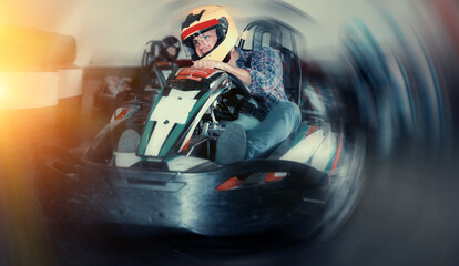 Portrait of adult man driving racing car at kart circuit © JackF