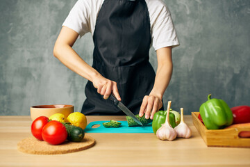 woman on the kitchen cutting vegetables salad