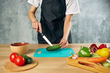Woman in black apron lunch at home vegetarian food cutting board