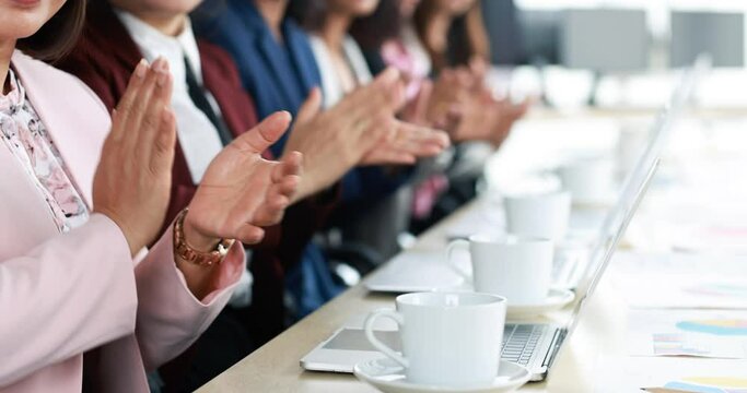Group of businesswomen in suit sitting at working desk and clapping hands for appreciating to someone in modern office company. Concept of good circumstance in company with friends and colleagues.