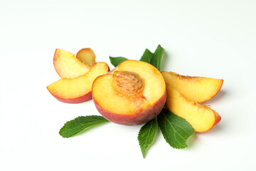 Ripe peach fruit with leaves on white background
