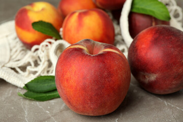 String bag with peach fruits on gray textured table