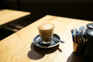 Side view shot of coffee art in a cup and a teaspoon in a table