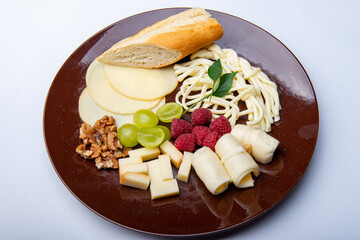 Cheese plate with nuts, raspberries and olives