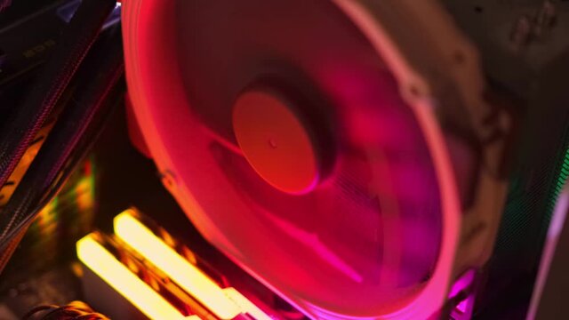 DIY computer building, pc gamers and pc enthusiast concept. High end computer cooling fan with big heat sink illuminated by RGB LED light in high end gaming pc system.