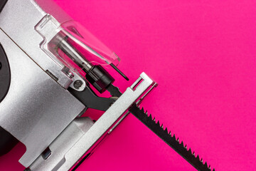 Hand electric tool on a pink background. Electric jigsaw.