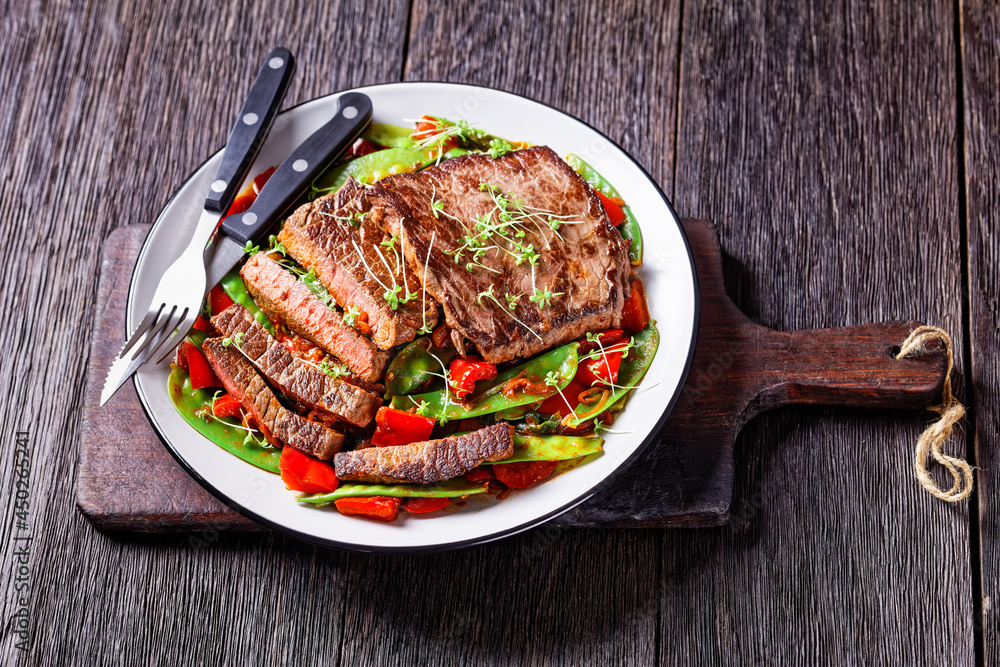 Poster grilled beef flank steak with braised vegetables