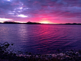 Fototapeta na wymiar Purple and pink sunset over the water