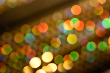 Abstract colorful glowing rainbow drops and sparkles on dark background. Rainbow bokeh in lines overlay.