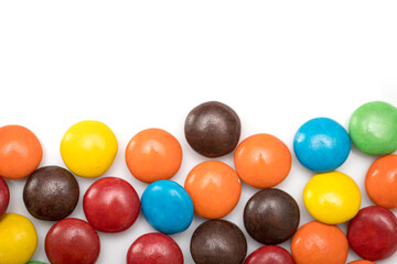 Variety of colorful candies coated on white background