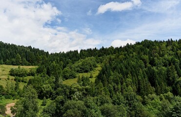 Clouds over the Ochotnica Gorna vilage hills during summer day