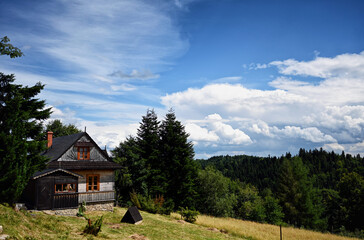 Fototapeta na wymiar Clouds over the vilage house in Ochotnica Gorna vilage during summer day