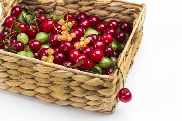 Cherries, gooseberries, currants in wicker basket.