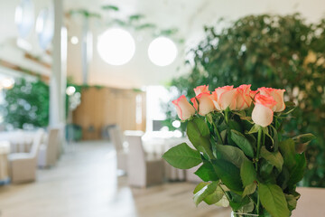 A bouquet of beautiful white pink roses in a glass vase on the banquet table. Copy Space