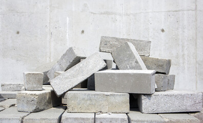 A pile of cement type bricks. Solid brick is used for construction. Lots of loose concrete bricks...