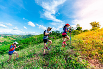 Three trail runners, a woman and an Asian man. Wearing runners, sportswear, practicing running on a...