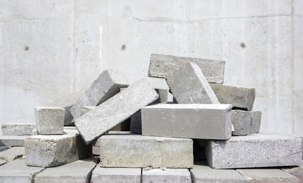 A pile of cement type bricks. Solid brick is used for construction. Lots of loose concrete bricks at the construction site.