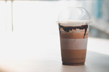 Iced mocha with cocoa sauce in plastic cup.