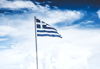The national flag of Greece, blue and white, on cloudy sky background