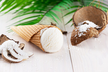 Coconut ice cream with a palm branch on a white wooden table.