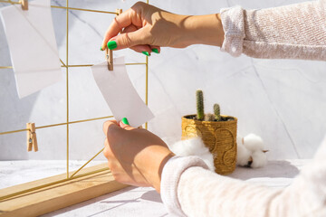 Woman creating mood board. Cards and posters mock ups on grid board. Copy space. Feminine hipster...