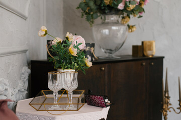 Wine glasses and a bouquet of flowers in a vase in the living room as a home decor