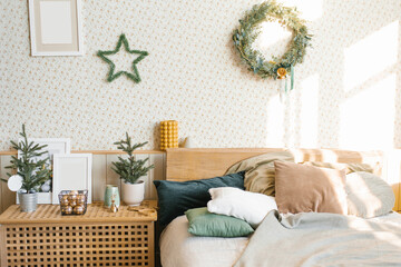 A bed with pillows and Christmas decorations in the bedroom in a Scandinavian style.