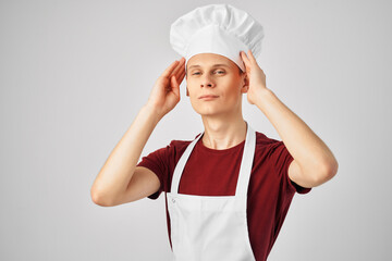 man in a white apron with a cap on his head working uniform kitchen