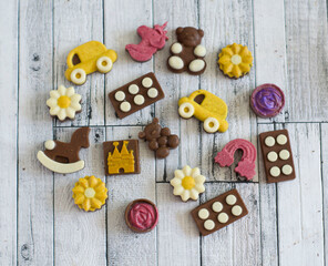 Mini handmade colored chocolates from kerob in the shape of a car, a flower, a bear, a grasshopper.