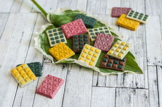 Mini colored handmade chocolates from kerob on a green leaf.