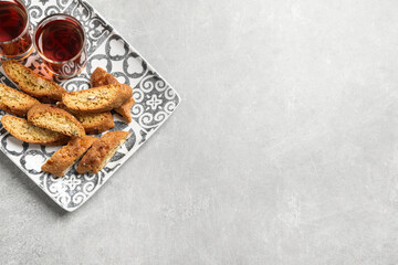 Tasty cantucci and glasses of liqueur on light table, top view with space for text. Traditional...