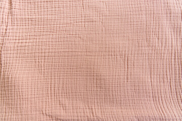 Soft muslin baby blanket background. Cotton clothing and textiles. Natural organic fabrics texture. Light pink rose, dusty rose color. Close up. Top view - obrazy, fototapety, plakaty