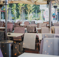 Empty street cafe in European city with blankets on chairs