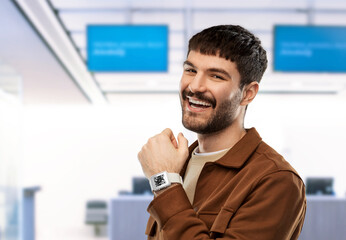 technology, health and people concept - smiling young man with qr code on screen of smart watch over grey background