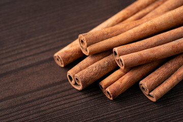 Macro shot of many cinnamon sticks on dark wooden background. Cinnamon on the table