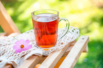 A calm pleasant still life in the garden with a mug of tea and flowers in summer