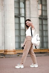street style shot of a girl. photo of a young girl on the background of the building, columns.